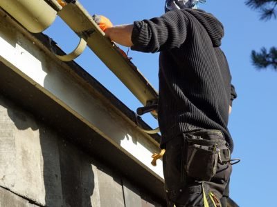A low angle shot of a construction worker working and fixing a roof